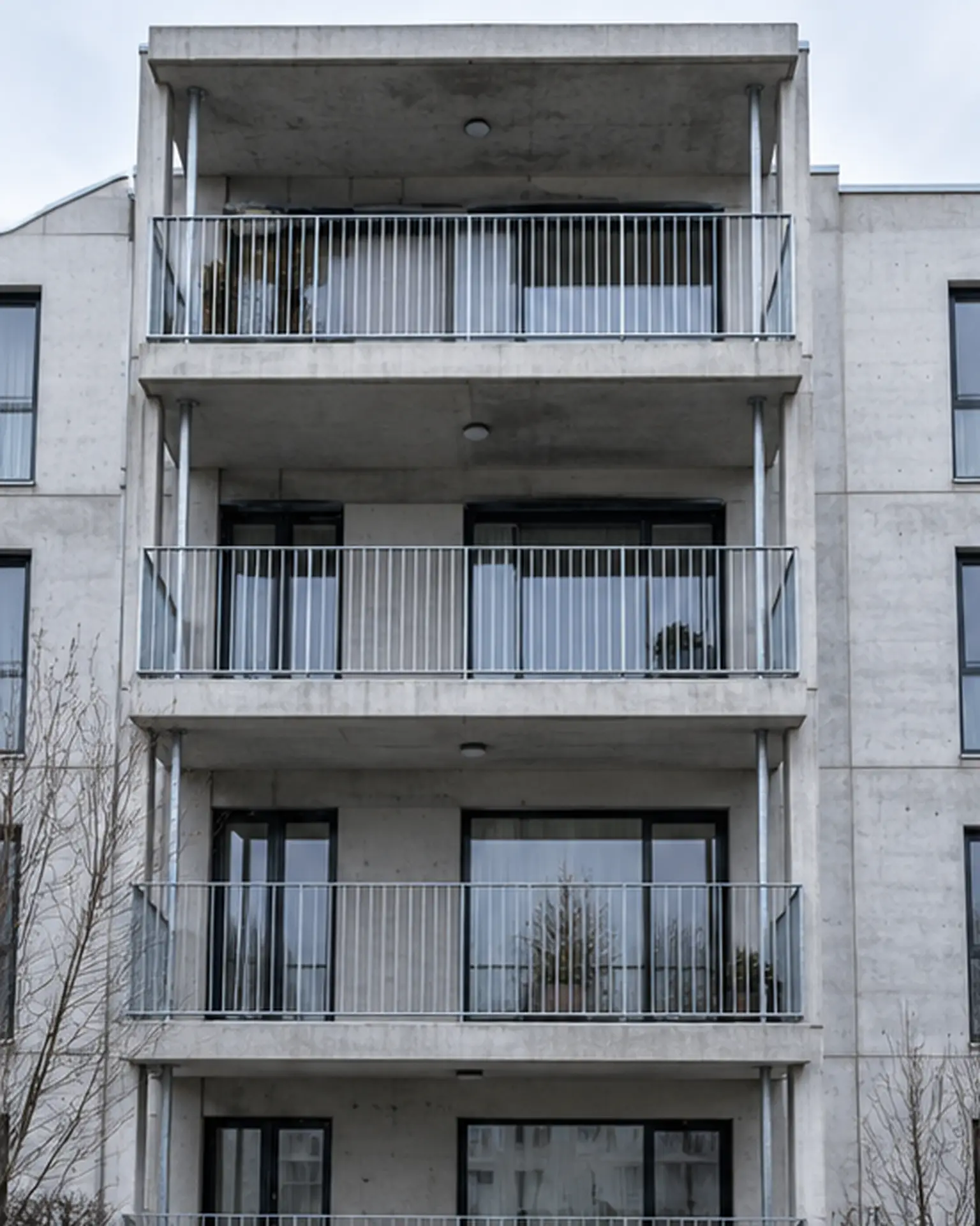 Stahlgeländer an einer Betonfassade im Winterlicht